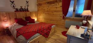 a bedroom with a bed in a room with wooden walls at Les Grosses Pierres à Spa in Spa