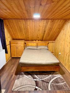 a bedroom with a bed in a wooden cabin at Cabana SVA Bilbor in Bilbor