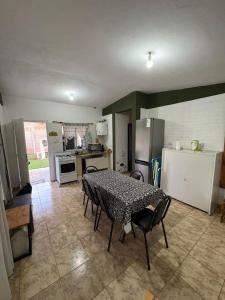 a kitchen with a table and some chairs and a refrigerator at Las tres lunas 2 in Villa Anizacate
