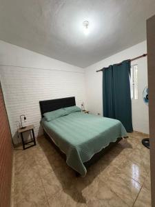 a bedroom with a bed and a blue curtain at Las tres lunas 2 in Villa Anizacate