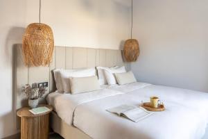 a bedroom with a large white bed with two baskets at Norte Luxury Villas in Agioi Apostoli +91 photos