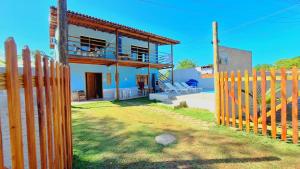 a house with a wooden fence in front of it at Paraíso Azul in Ilhéus