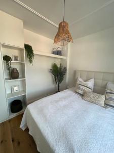 a bedroom with a white bed and a potted plant at Wanderlust East73 in Trier