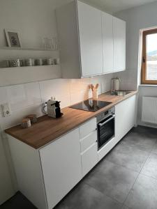 a kitchen with white cabinets and a wooden counter top at Wanderlust East73 in Trier