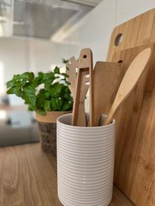 a cup filled with wooden spoons and spatulas on a table at Wanderlust East73 in Trier