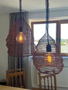 two netted lights hanging over a table with chairs at Wanderlust East73 in Trier +13 photos