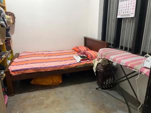 a small bed in a room next to a wall at Liyos House in Matara