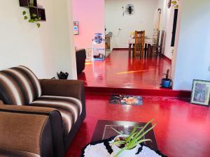 a living room with a couch and a red floor at Liyos House in Matara