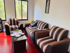 a living room with two couches and a table at Liyos House in Matara +3 photos