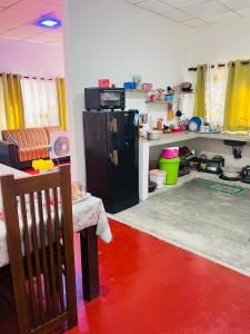 a room with a refrigerator and a red floor at Liyos House in Matara