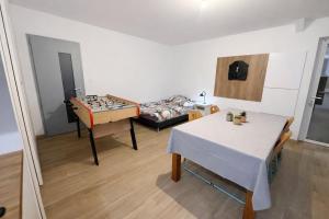 a living room with a table and a bed and a table and a table at Grand studio équipé indépendant in Guipry-Messac