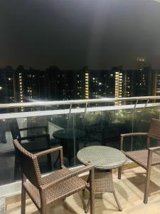 two chairs and a table on a balcony with a city skyline at cozy noida studio, super comfy!!!! in Noida