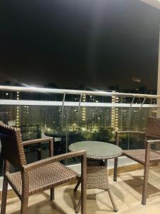 a table and chairs on a balcony with a view at cozy noida studio, super comfy!!!! in Noida