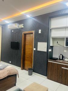 a room with a kitchen with a bed and a television at cozy noida studio, super comfy!!!! in Noida