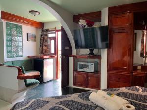 a bedroom with a bed and a flat screen tv at Hotel Las Flores in Xalapa