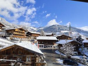 a town with snow covered buildings and a mountain at Ferienwohnung Haus Sama in Alpbach +7 photos