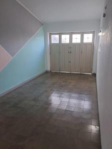 an empty room with doors and a tile floor at Chalet Ferrari in Mina Clavero