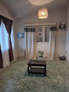 a living room with a coffee table and curtains at Chalet Ferrari in Mina Clavero