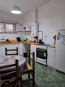a kitchen with a table and a stove and a refrigerator at Chalet Ferrari in Mina Clavero +5 photos