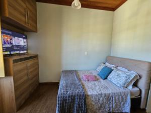 a small bedroom with a bed and a flat screen tv at Solar das Oliveiras in Ibertioga +91 photos