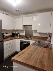 a kitchen with white cabinets and a wooden counter top at Modern 2BR House Sleeps 5 Free Parking Contractor Friendly Van parking in Middlesbrough