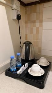 Ein Teekessel, Teller und Wasserflaschen auf einem Tablett in der Unterkunft فواصل2 in Tabuk