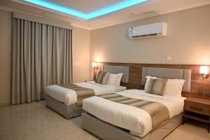 two beds in a hotel room with aperature at شاطئ العرب الرايس in Rayyis