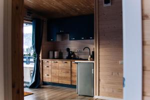 a kitchen with wooden cabinets and a sink and a refrigerator at Sungora sun&ski resort in Slavske