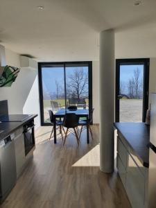 a kitchen with a table and a dining room at Le repos tranquille in Mercury