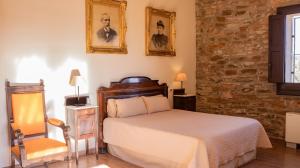 a bedroom with a bed and a chair at La Torre del Vilar in Santa Eulalia de Ríuprimer +75 photos