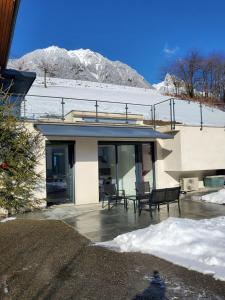 a house with a patio with chairs in the snow at Le repos tranquille in Mercury