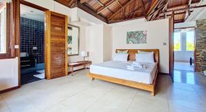 a bedroom with a bed and a walk in shower at Holiblue in Blue Bay