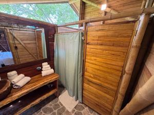 a bathroom in a log cabin with a shower and towels at Anahari Centro Wellness in Quimbaya +49 photos