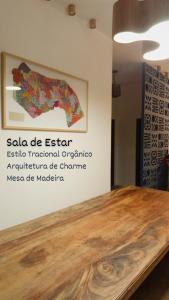 a wooden table with a painting on a wall at Casa Passarela in Icapuí