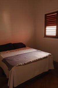 a bed in a bedroom with a window at Casa Passarela in Icapuí +46 photos