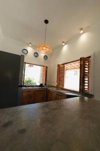 a kitchen with a counter top and two windows at Casa Passarela in Icapuí
