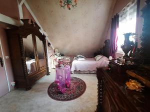 a room with a bedroom with a bed and a table at Chambre d hôte les bosquets in Caugé