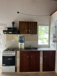 a kitchen with a stove and a sink and a window at Casa de playa Camping Chajarí in Santa Ana +14 photos