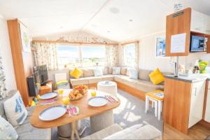 a caravan living room with a table and a couch at Springfield B6 in Brixham