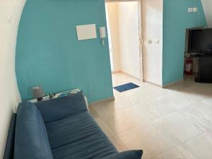 a blue living room with a couch and a television at Levante al porto in Bisceglie