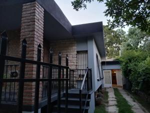 a house with a black fence and stairs at Conti House in Capilla del Monte