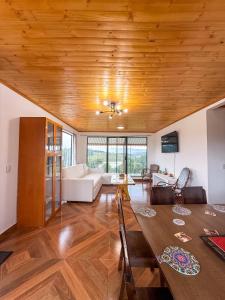a living room with a wooden ceiling and a table at Finca Siberia, Sisga in Tilatá