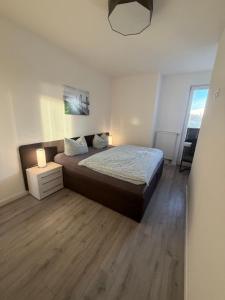 a bedroom with a large bed with a wooden floor at Seglerblick in Greifswald