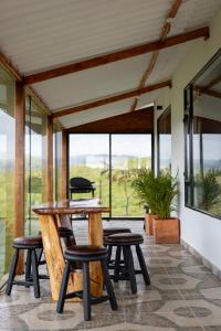 a patio with a table and chairs and a window at Finca Siberia, Sisga in Tilatá