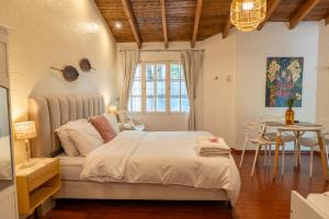 a bedroom with a large bed and a table at "Casa Amalia Apartamentos" Plaza Italia y Arístides a media cuadra, Ubicación Exclusiva Top in Mendoza