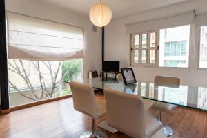 a dining room with a glass table and chairs at "Casa Amalia Apartamentos" Plaza Italia y Arístides a media cuadra, Ubicación Exclusiva Top in Mendoza