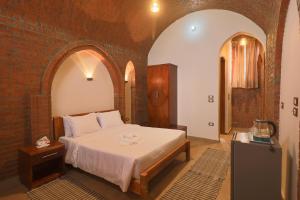 a bedroom with a bed and a brick wall at Golden Land in ‘Ezbet Abu Ḥabashi +230 photos