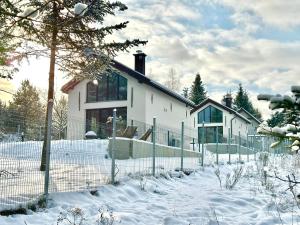 a white house with a fence in the snow at Bocian nad Bugiem in Mierzwice