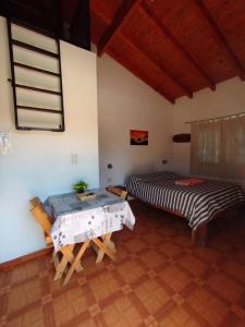 a room with two beds and a table at La Serena Cabañas in Potrero de los Funes +49 photos