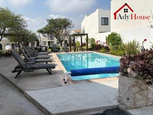 a swimming pool with lounge chairs next to a building at AdyHouse Ziré in Buena Vista